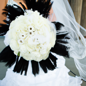 A white bridal bouquet with lush, long, black eyelashes draped across it.