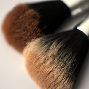 A close-up of two makeup brushes with different shades of brown, angled to create a contrast.