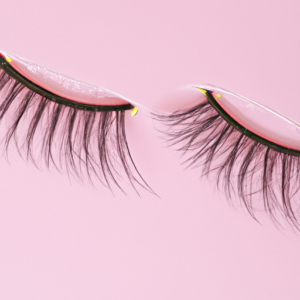 A closeup of a pair of false eyelashes against a pink background.