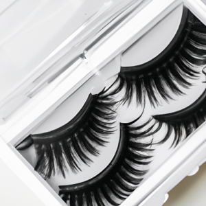 A close-up of a pair of false eyelashes in a clear plastic box.