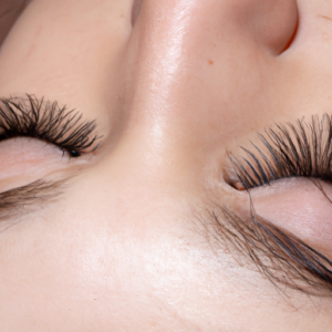 A close-up of a set of long, healthy eyelashes with a subtle sparkle to them.