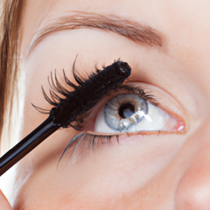 Close-up of a pair of eyes with mascara being applied to the bottom lashes
