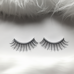 A pair of false eyelashes on a bed of white cotton.