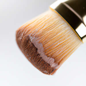 A close-up of a makeup brush with foundation on its bristles.