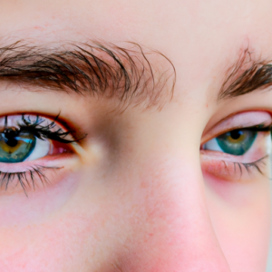 A close-up of a pair of eyes with vibrant, thick, curled eyelashes.