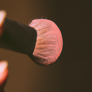 A close-up of a makeup brush lightly dabbing onto the skin.