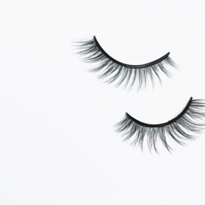 A close-up of a pair of false eyelashes laid out against a white background.